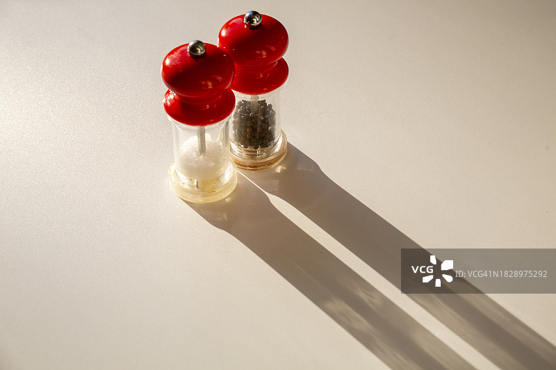 明媚的阳光洒在复古盐和胡椒研磨器上，投下长长的阴影图片素材