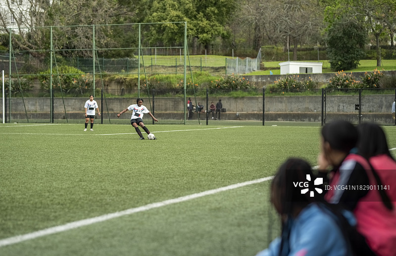 比赛中奔跑的年轻女足球运动员图片素材