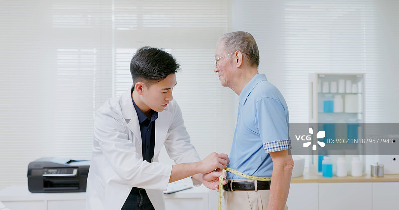 营养师测量老年男人的腰围图片素材