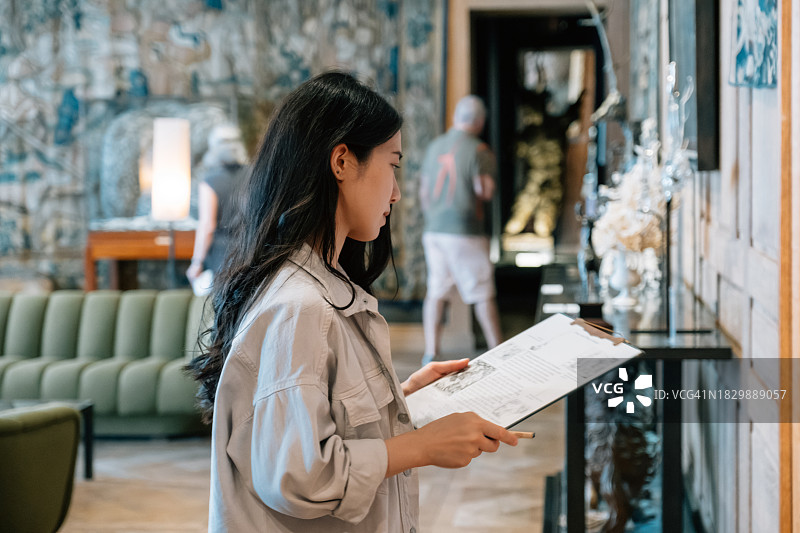 在现代办公室使用剪贴板工作的时尚亚洲女性的肖像图片素材