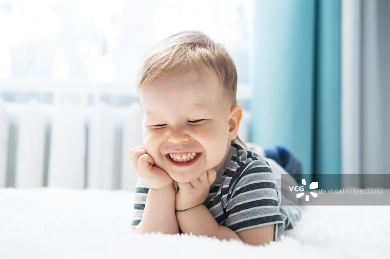 快乐的小男孩躺在床上图片素材