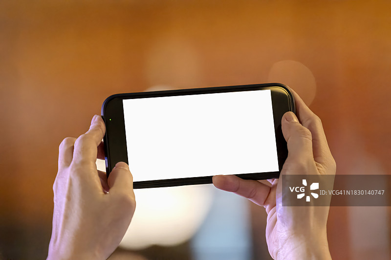 女人在家使用手机，空白屏幕背景特写图片素材