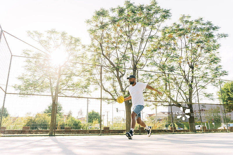 亚洲男人在运动场训练，投篮图片素材