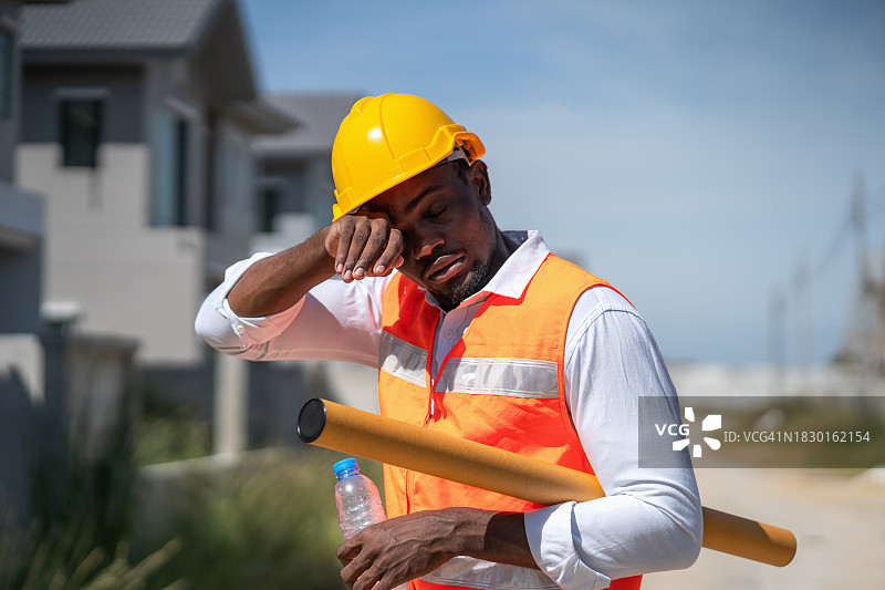 建筑工地的工人长时间暴露在阳光下感到疲倦图片素材