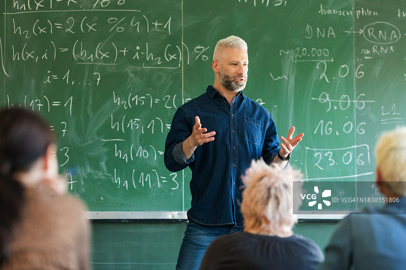 站在黑板前的中年教师图片素材