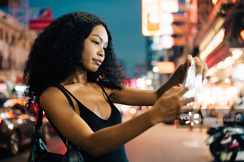 亚裔女子独自在城市里漫步图片素材