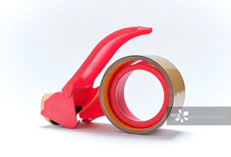 白色背景下的红色塑料胶带切割器图片素材