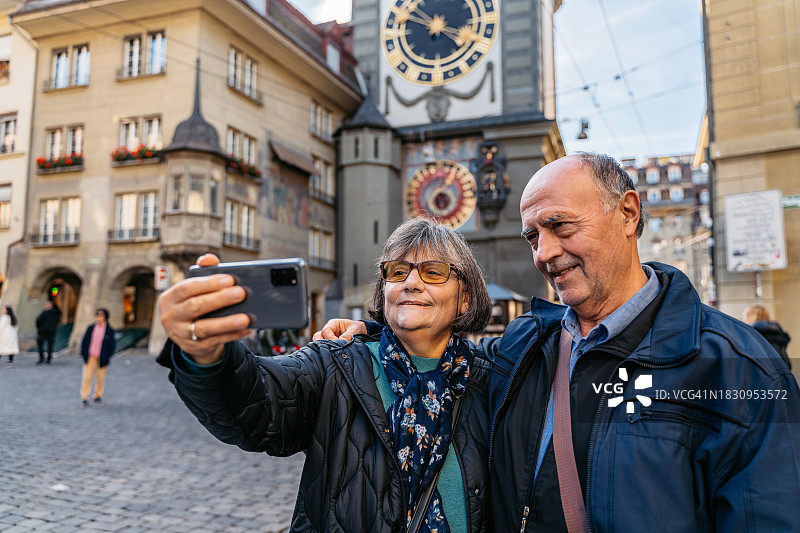 老年游客夫妇在伯尔尼 Zeitglockenturm 钟楼前自拍图片素材