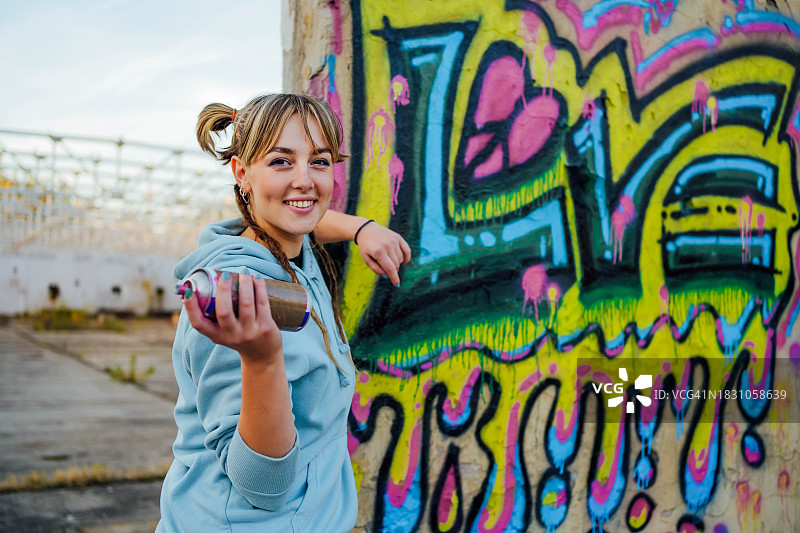拿着喷漆罐的女涂鸦艺术家图片素材