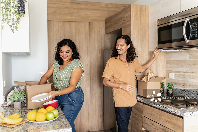 中年 женщина в новом доме распаковывает装有厨房用具的箱子图片素材