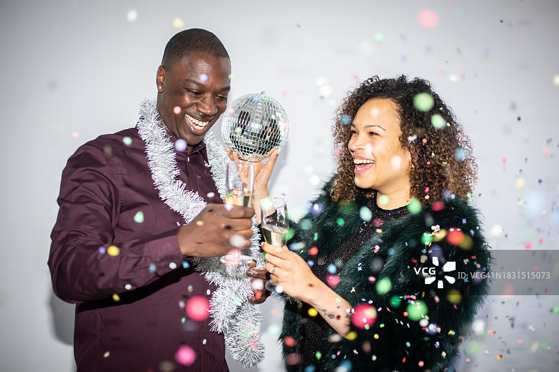 一对夫妇、迪斯科球、香槟和金属箔图片素材
