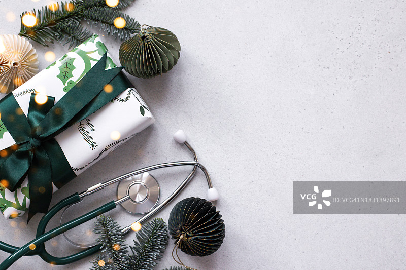 带有文本位置的节日背景：圣诞节祝福语、听诊器、礼品盒和圣诞装饰品图片素材