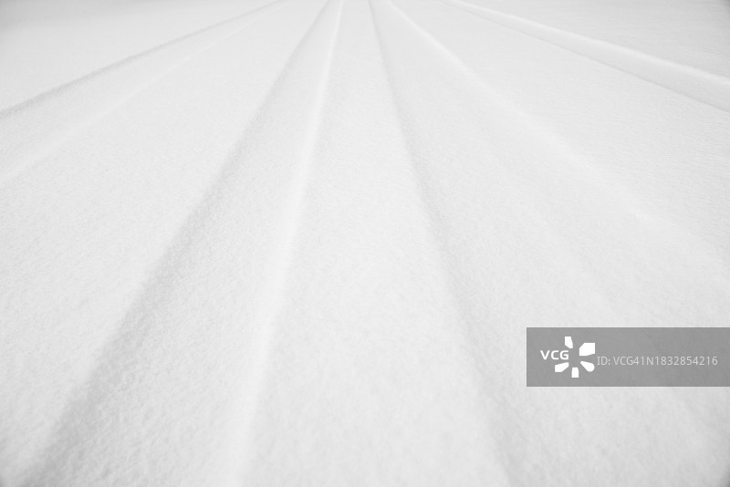 白色雪地上汽车轨迹的特写图片素材