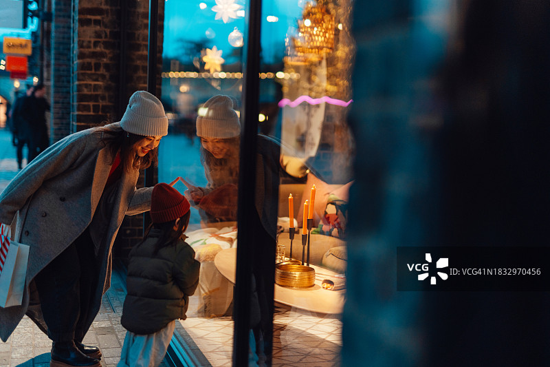 年轻的亚洲母亲和女儿在高街上进行圣诞购物图片素材