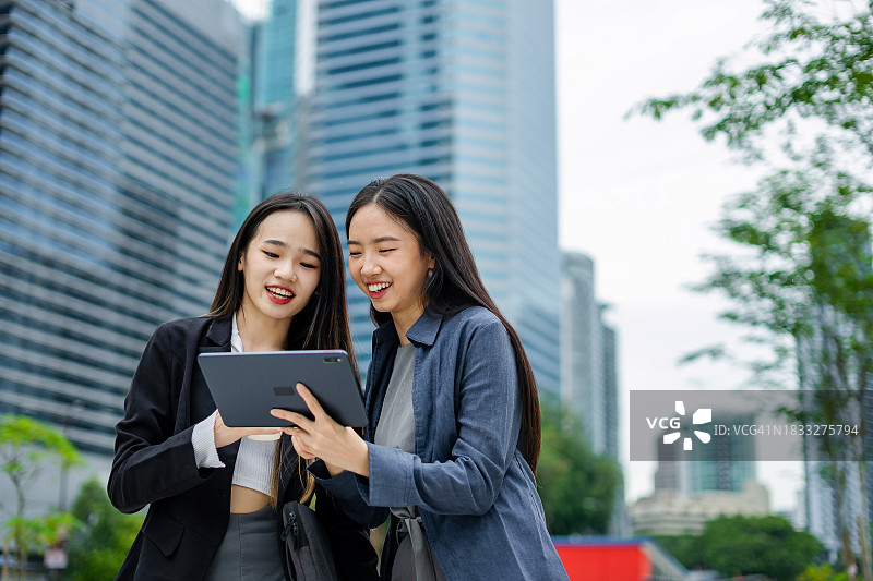 女朋友们在城市里使用平板电脑图片素材