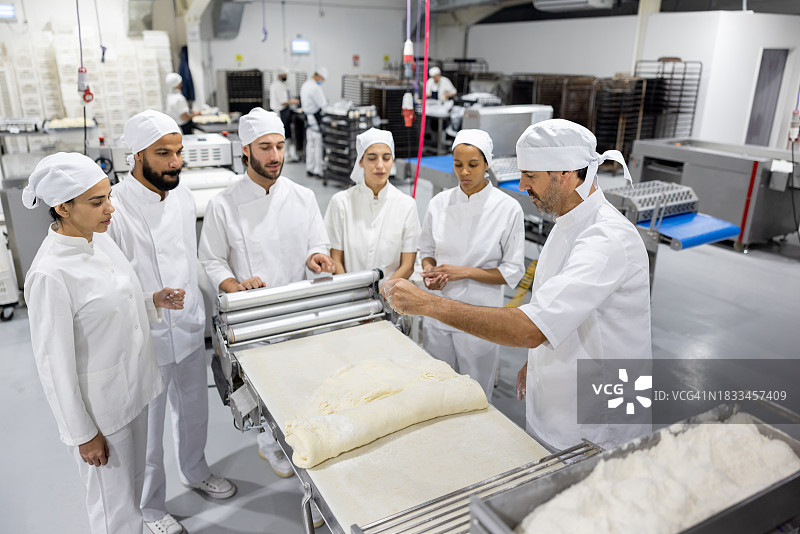 面包师在食品加工厂培训一群新员工图片素材