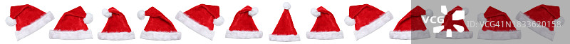 圣诞节与圣诞老人帽：德国斯图加特，一排圣诞老人帽在白色背景前裁剪图片素材