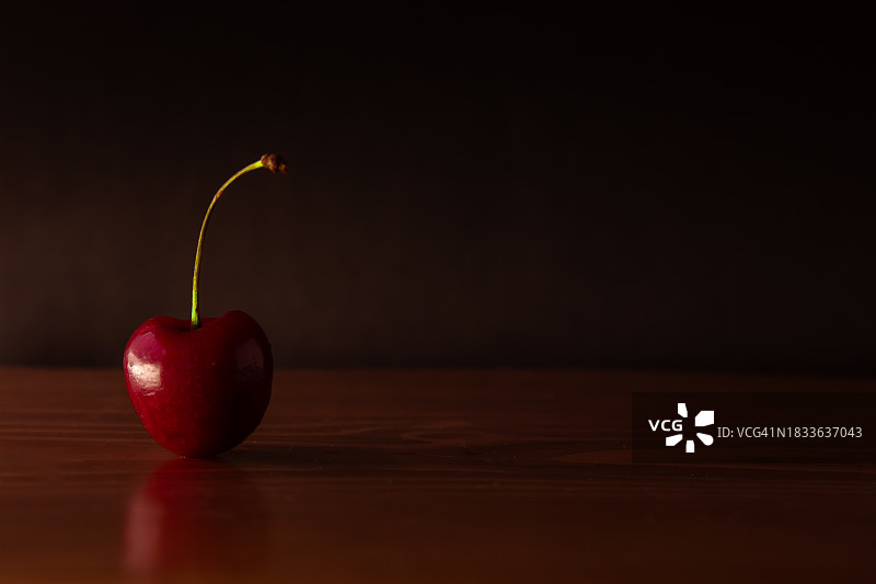 黑色背景下桌子上樱桃的特写图片素材