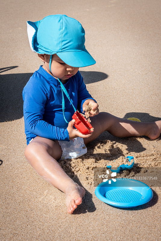 男孩在海滩上玩沙子图片素材