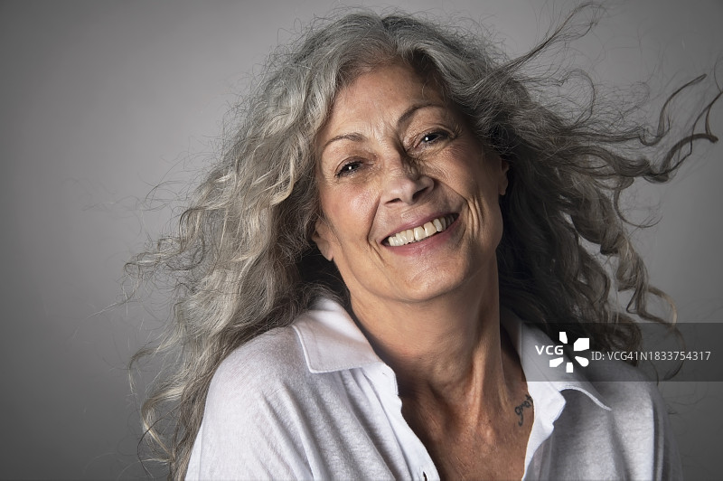 拥有灰色头发的老年妇女的棚拍肖像图片素材