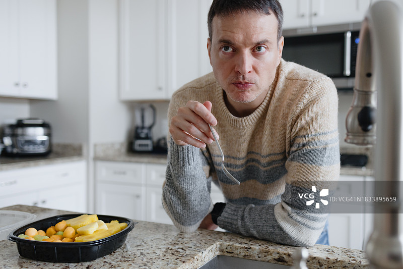 男子在厨房吃水果图片素材