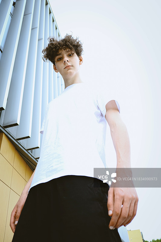 青少年站在天空下的建筑物旁图片素材