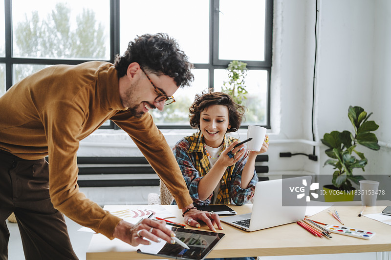 在办公桌前一起工作的快乐平面设计师图片素材