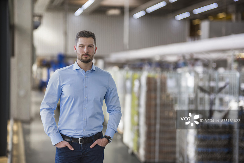 自信的工程师双手插在口袋里站在工业场所图片素材