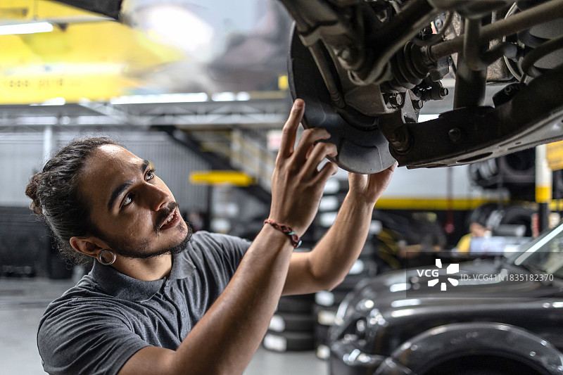 男人维修汽车刹车盘图片素材
