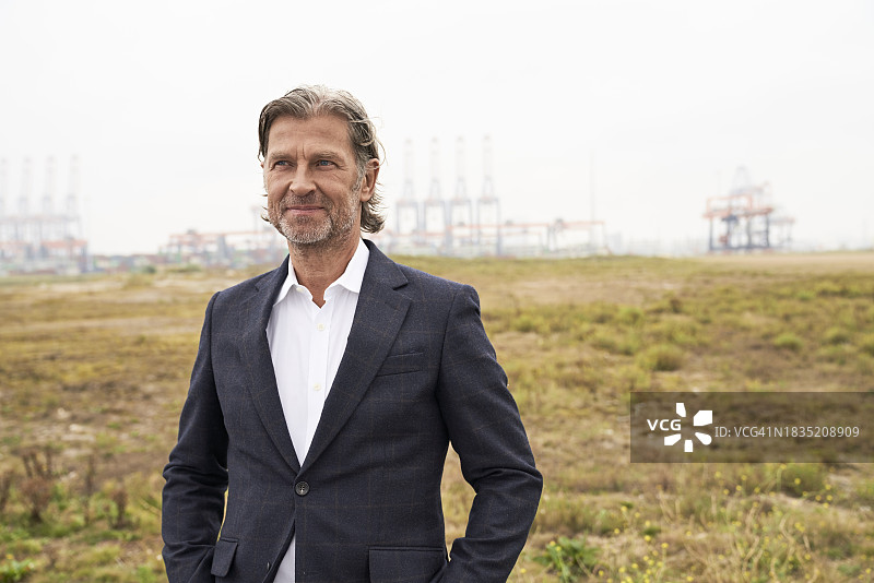微笑的老年商人站在工业区图片素材