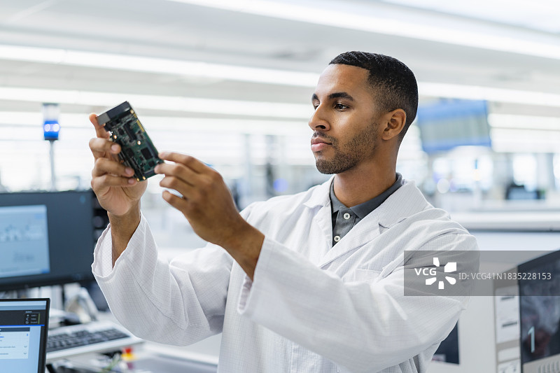 电子厂中检查主板的电子技术员图片素材