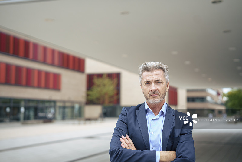 自信的商人双手交叉站立图片素材