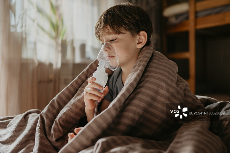 小学生在家用雾化器吸入药物图片素材