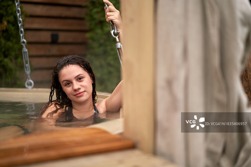 快乐的女人在浴缸里放松，抓住链条图片素材