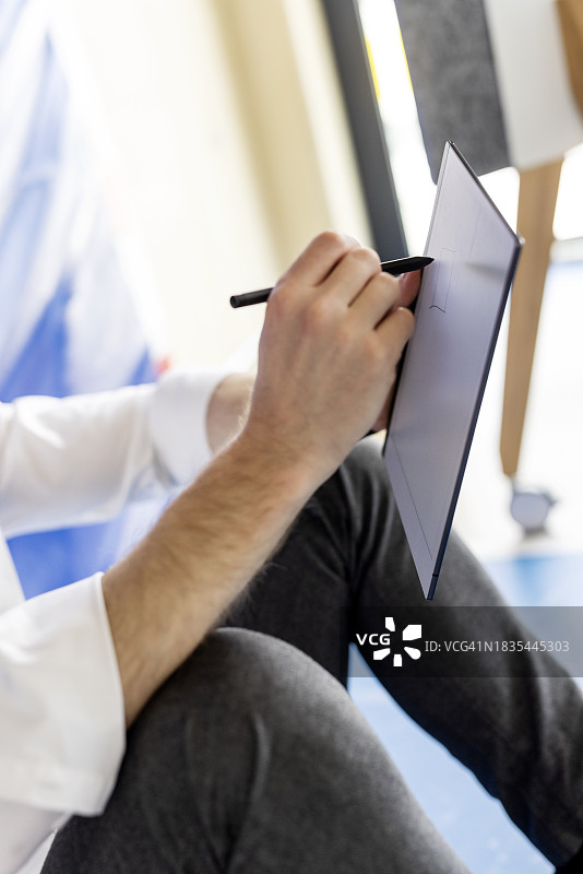 商务人士用数字化笔在平板电脑上书写图片素材