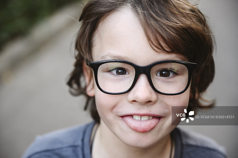 戴着眼镜吐舌头的顽皮男孩图片素材