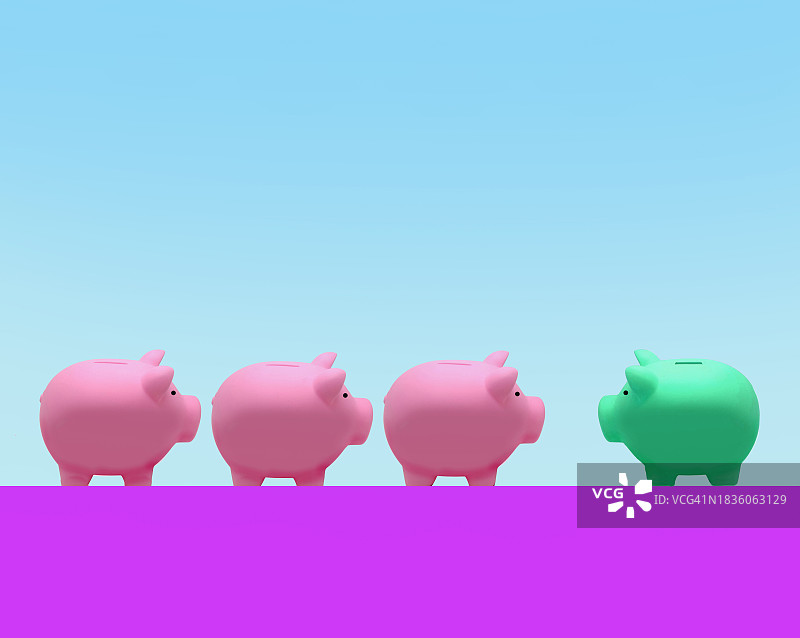 三个粉色小猪储蓄罐面对一个绿色小猪储蓄罐图片素材