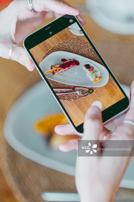 女人拍摄蛋糕的俯视图，用于社交媒体图片素材