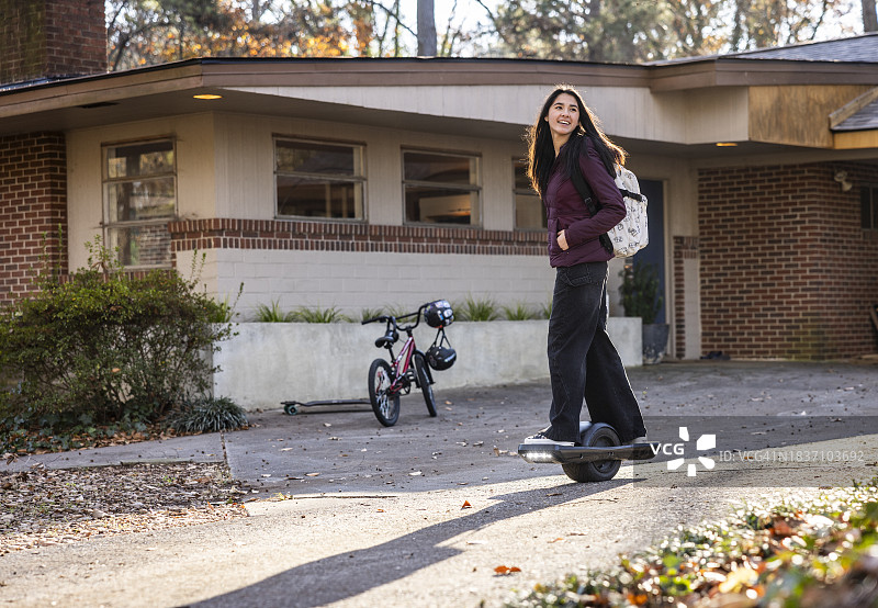 少女在家门前玩独轮滑板图片素材