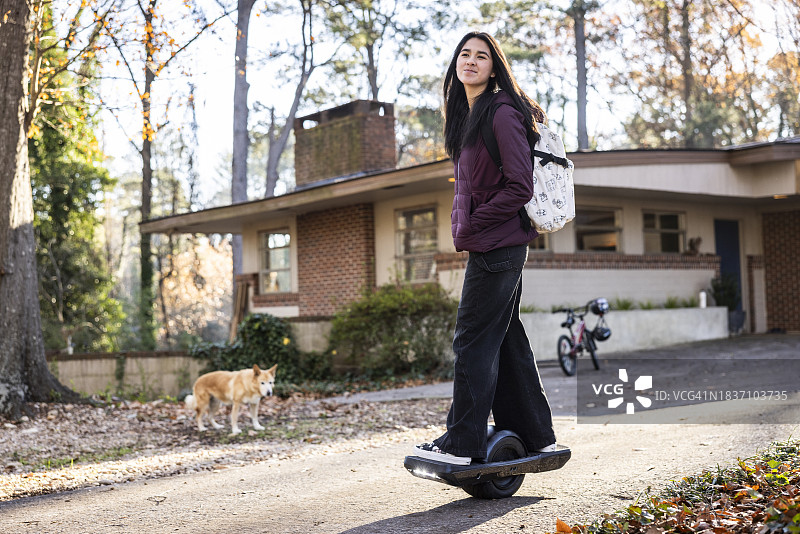 少女在家门前玩独轮滑板图片素材