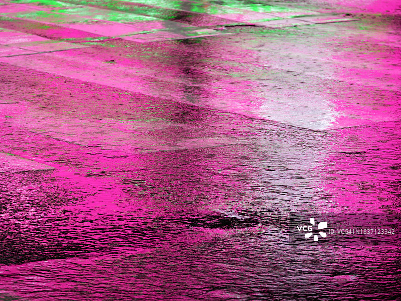 纽约曼哈顿雨后人行横道上反射的粉色和绿色灯光，无人图片素材