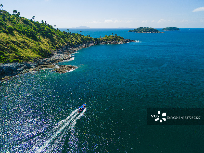 泰国普吉岛，长尾船在群山中航行至蓬贴海角的无人机鸟瞰图图片素材