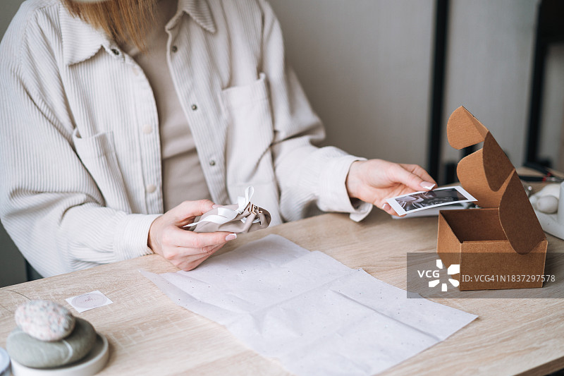小企业主年轻女人在工作室的办公桌上整理和包装在线订单图片素材