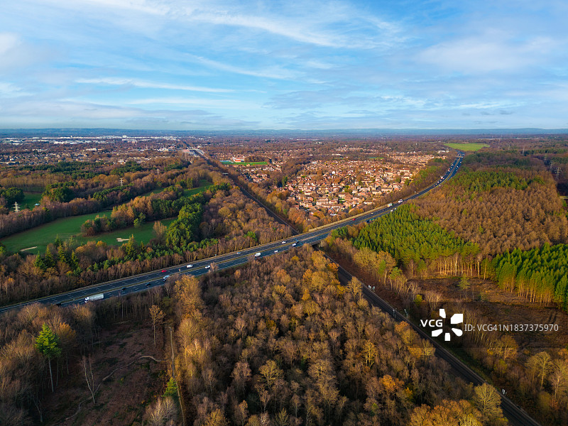 繁忙的高速公路穿过森林景观的无人机航拍图片素材