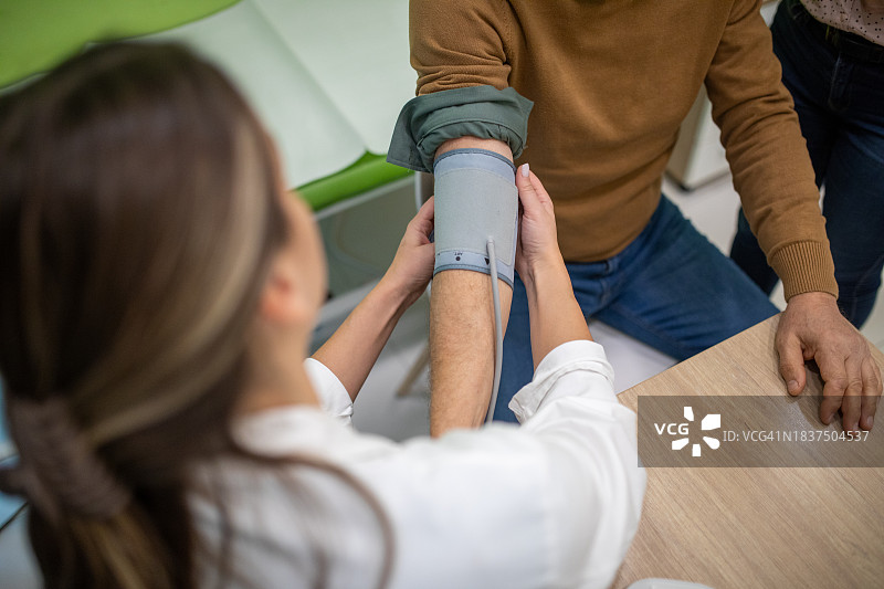 医生在诊所为老年男性测量血压图片素材