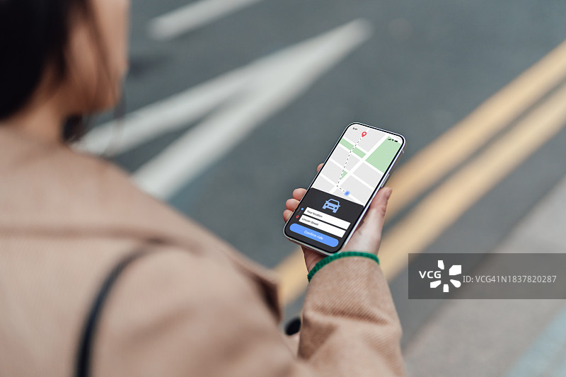 年轻女子通过智能手机上的移动应用程序订购出租车服务图片素材