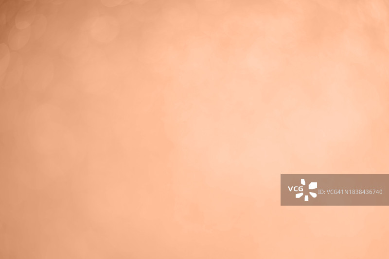 抽象圣诞散景模糊黄色灯光背景。展示潘通2024年流行色——桃色。图片素材