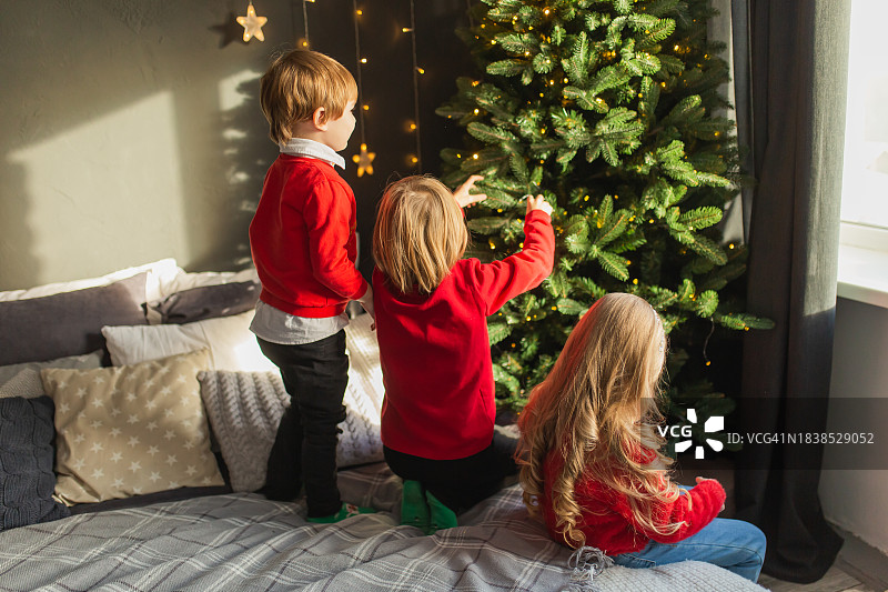 孩子们在家里穿着红色毛衣庆祝圣诞节图片素材