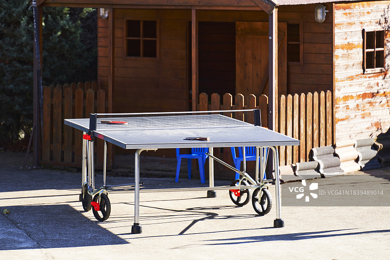 木屋花园里的乒乓球桌，有窗户，周围没有人图片素材