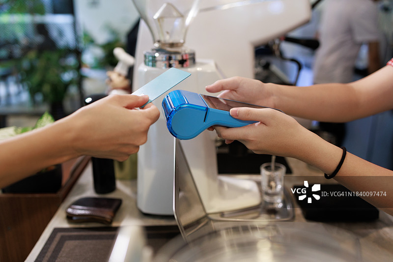 在商店中使用信用卡进行非接触式支付的特写图片素材